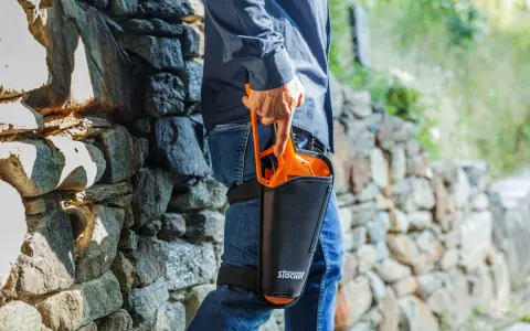 Uomo con forbici da potatura Stocker in fondina alla coscia, pronto per la potatura. Scopri come disinfettare le forbici da potatura per una cura ottimale delle piante.