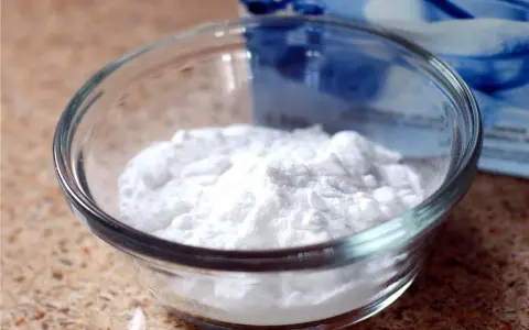 Mal bianco? Il bicarbonato è un rimedio naturale versatile. Ecco una ciotola piena di polvere bianca, pronta per ogni uso.