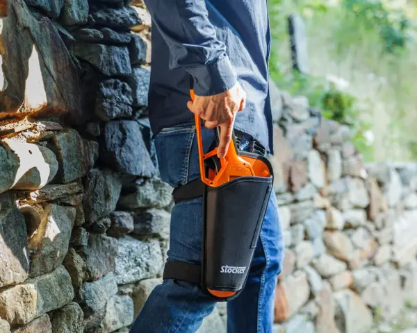 Uomo con forbici da potatura Stocker in fondina alla coscia, pronto per la potatura. Scopri come disinfettare le forbici da potatura per una cura ottimale delle piante.