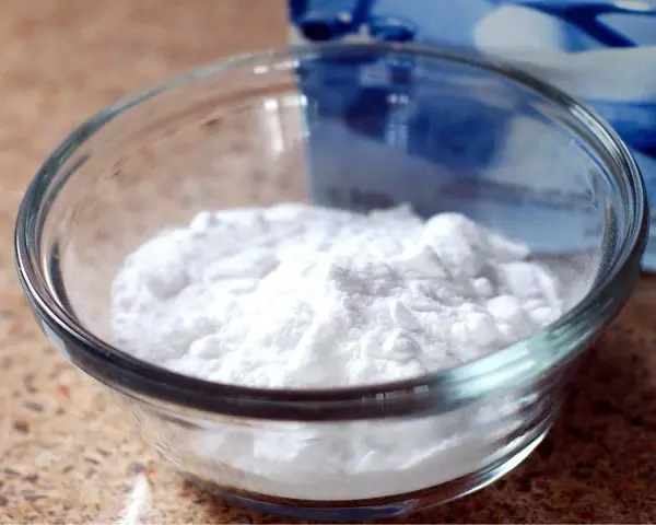 Mal bianco? Il bicarbonato è un rimedio naturale versatile. Ecco una ciotola piena di polvere bianca, pronta per ogni uso.