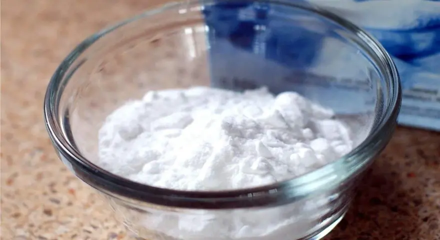 Mal bianco? Il bicarbonato è un rimedio naturale versatile. Ecco una ciotola piena di polvere bianca, pronta per ogni uso.